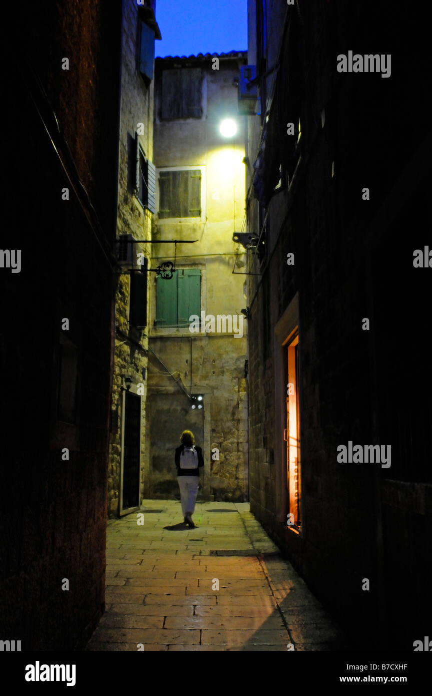 Single person walking down a street at night in Split Croatia Stock Photo