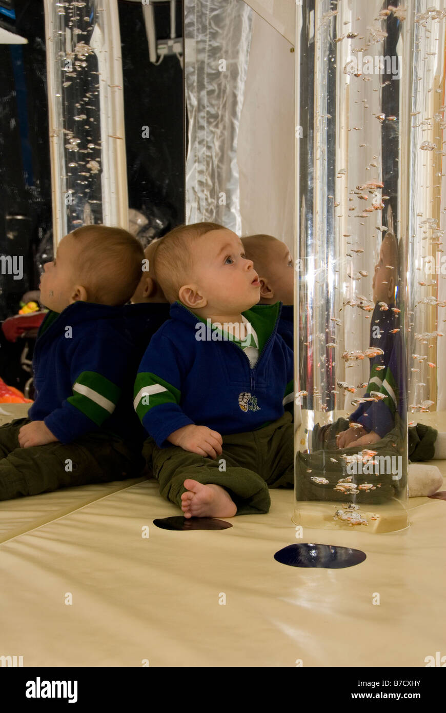 Baby Boy Looking at Coloured Bubbles Rising Up Inside Glass Tube in