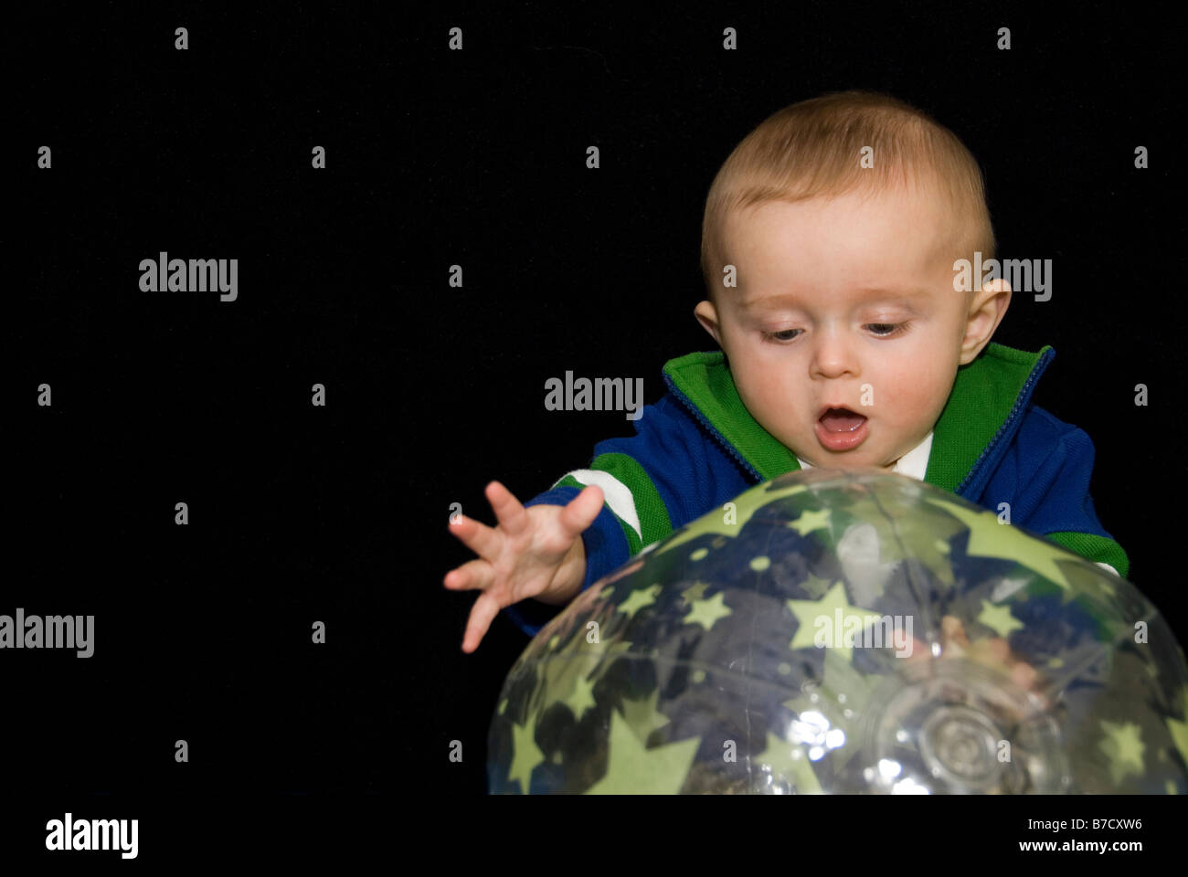Baby Boy Playing with Ultra Violent Reflective Toys in Dark of Surestart Sensory Play Room, Sheffield, England Stock Photo