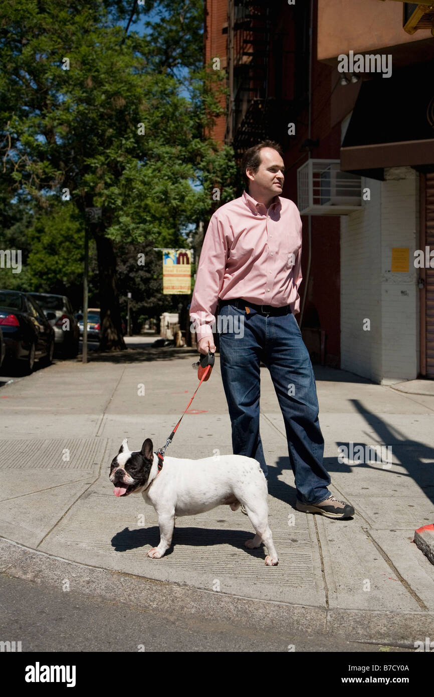 A French Bulldog on a leash and its owner, outdoors Stock Photo Alamy