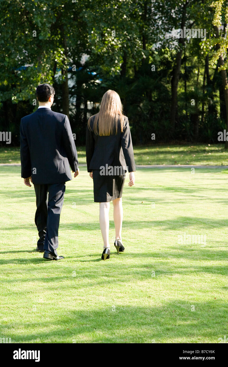 Two business people walking on the lawn rear view Stock Photo - Alamy