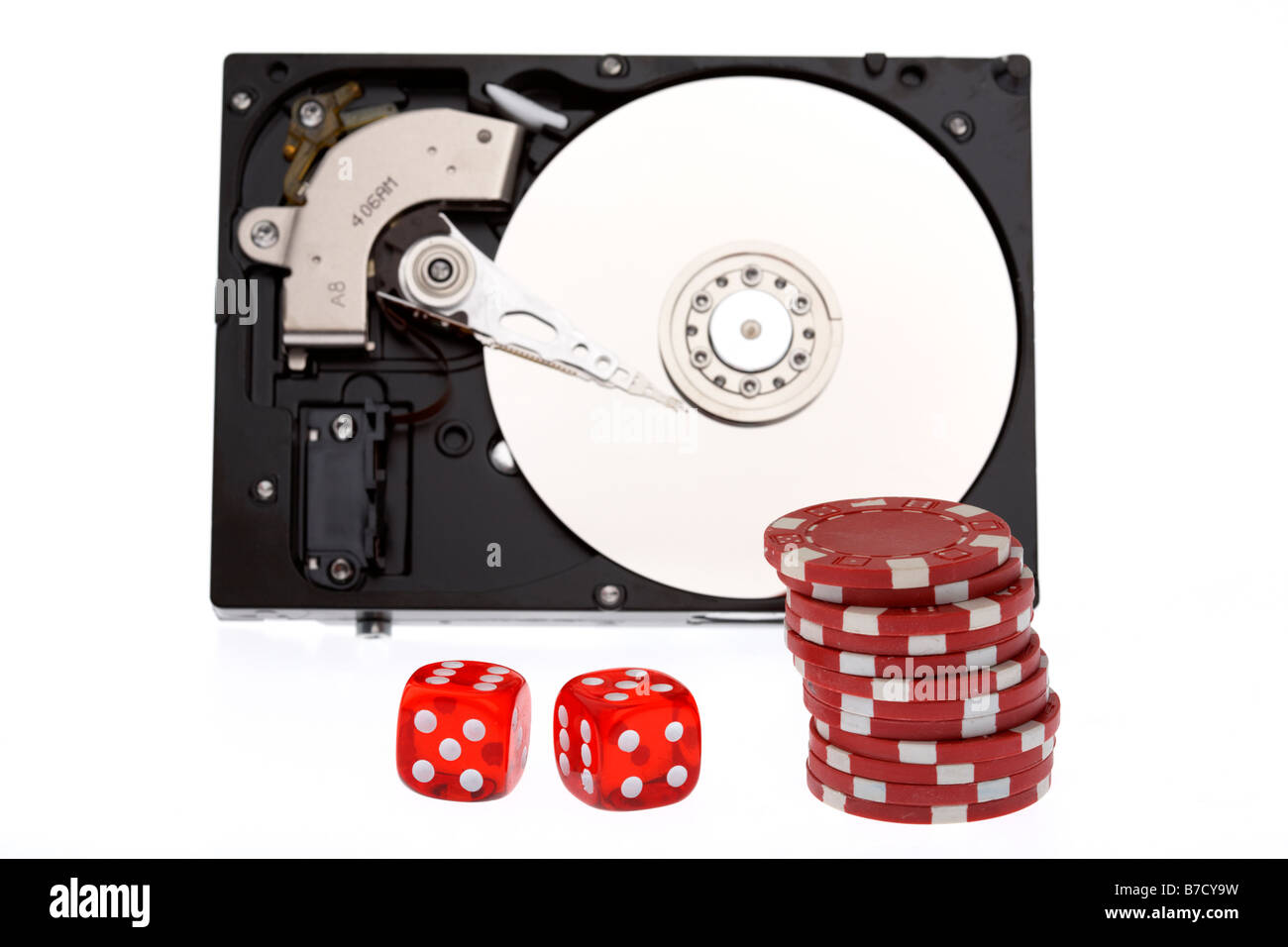 stack of poker chips and two dice in front of an opened computer hard drive on a white background Stock Photo
