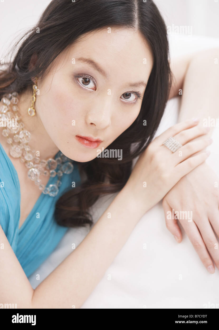 Woman in blue dress relaxed on sofa Stock Photo - Alamy