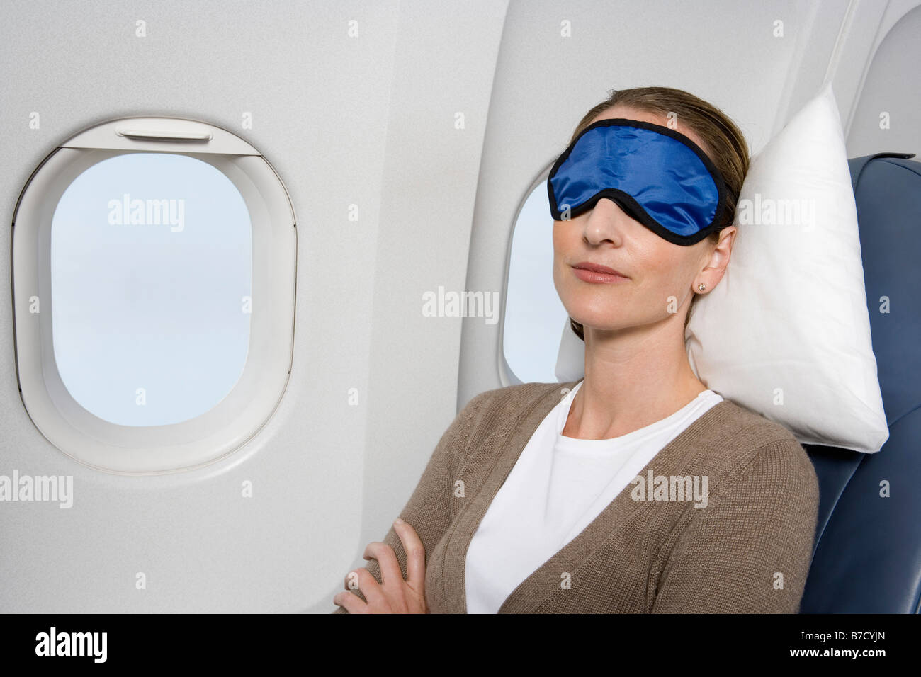 A woman wearing a sleep mask sleeping on a plane Stock Photo Alamy