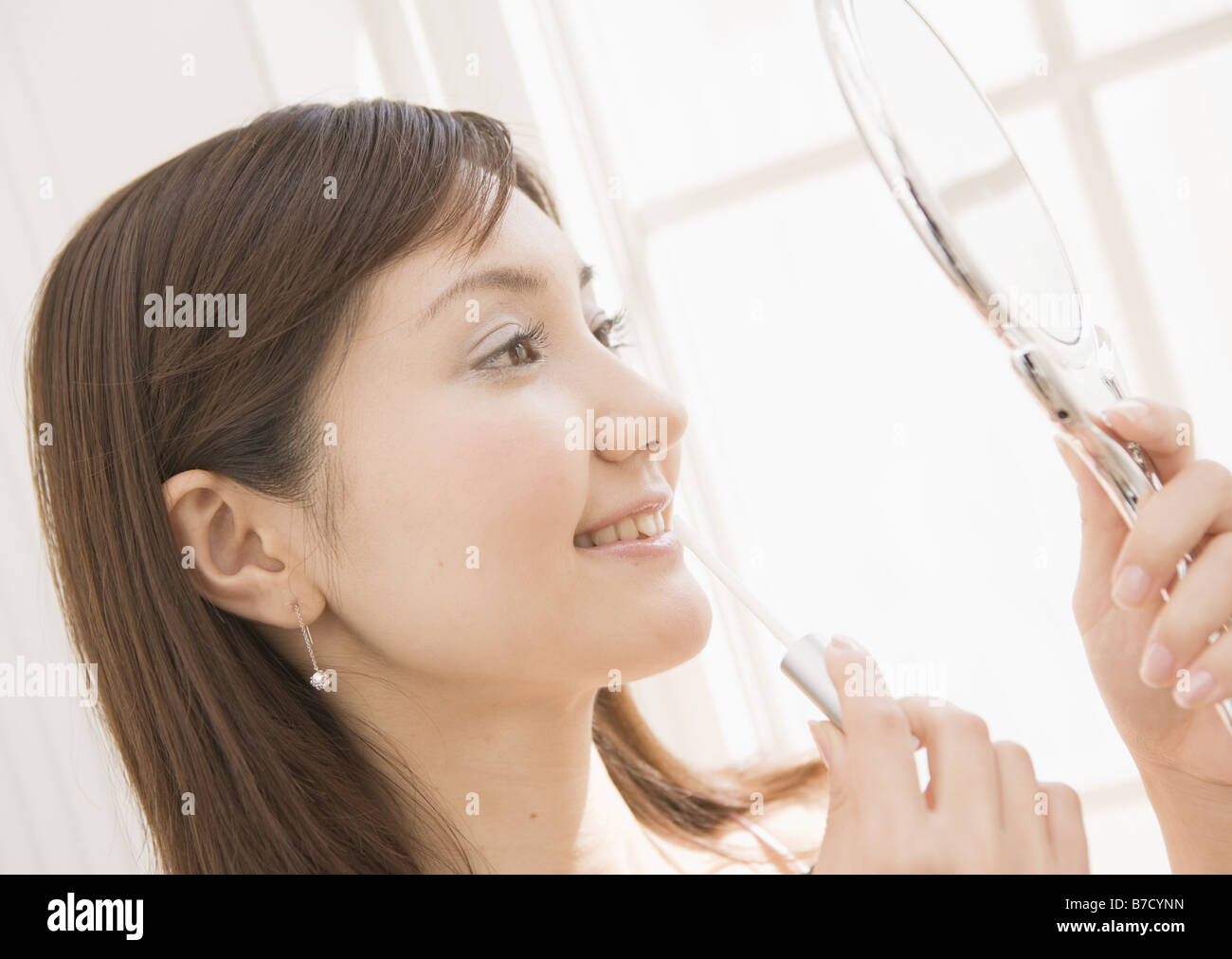 Woman applying lip gloss Stock Photo