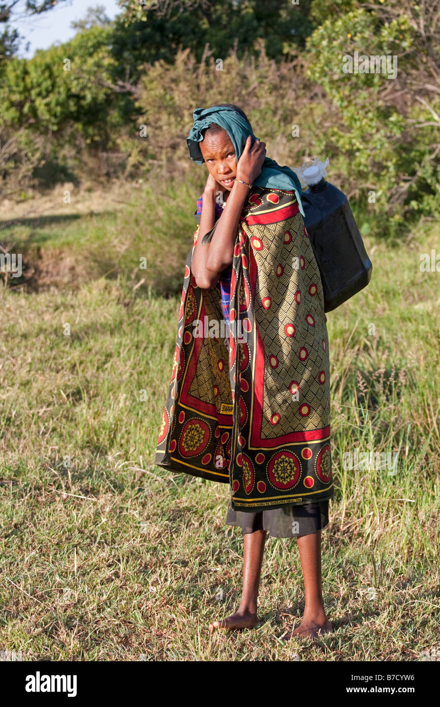 Masai girl carrying water from small stream Masai Mara North Reserve Kenya Stock Photo
