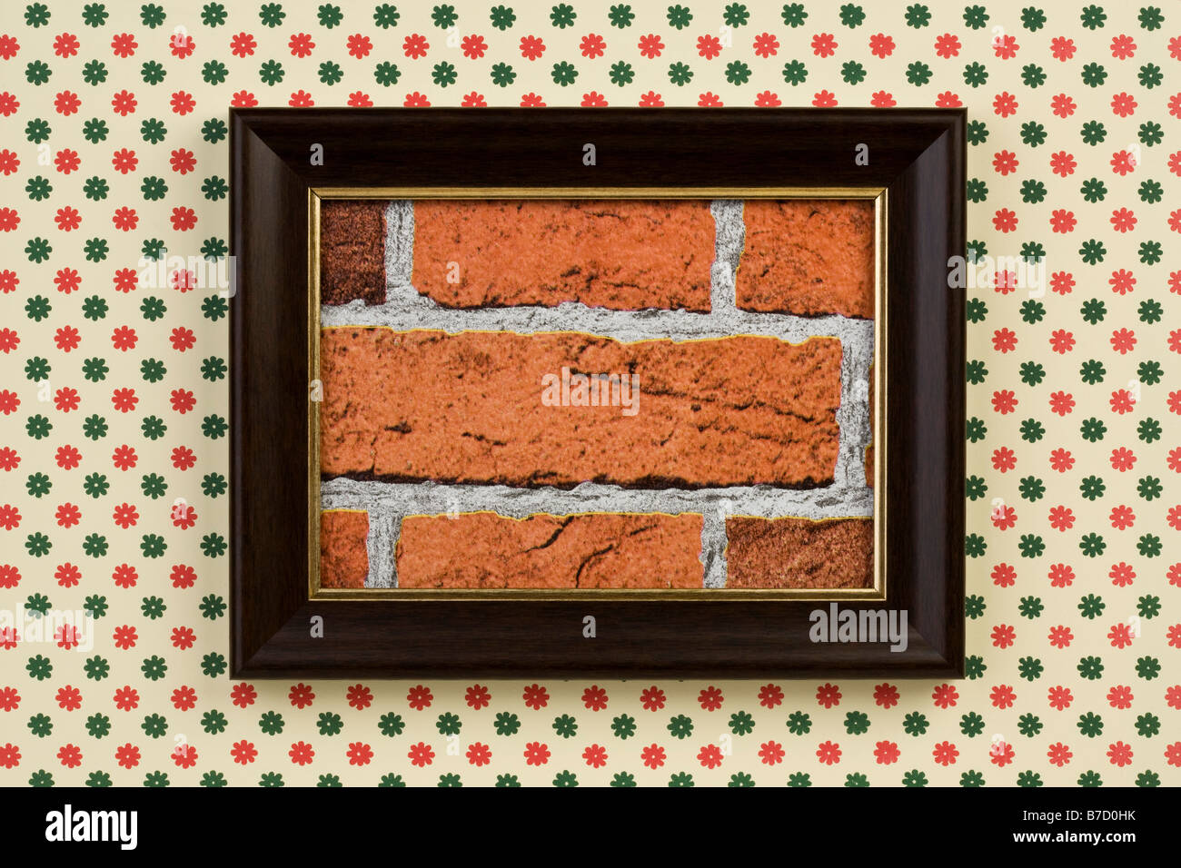 A framed picture of a brick wall hanging on a wallpapered wall Stock Photo
