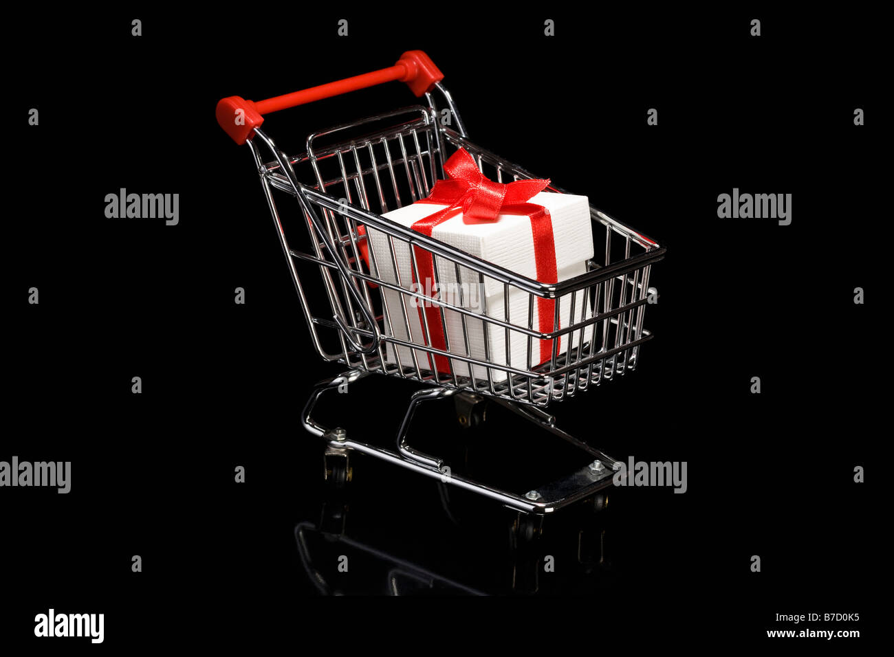 A shopping cart with a white box that has a ribbon wrapped around it Stock Photo