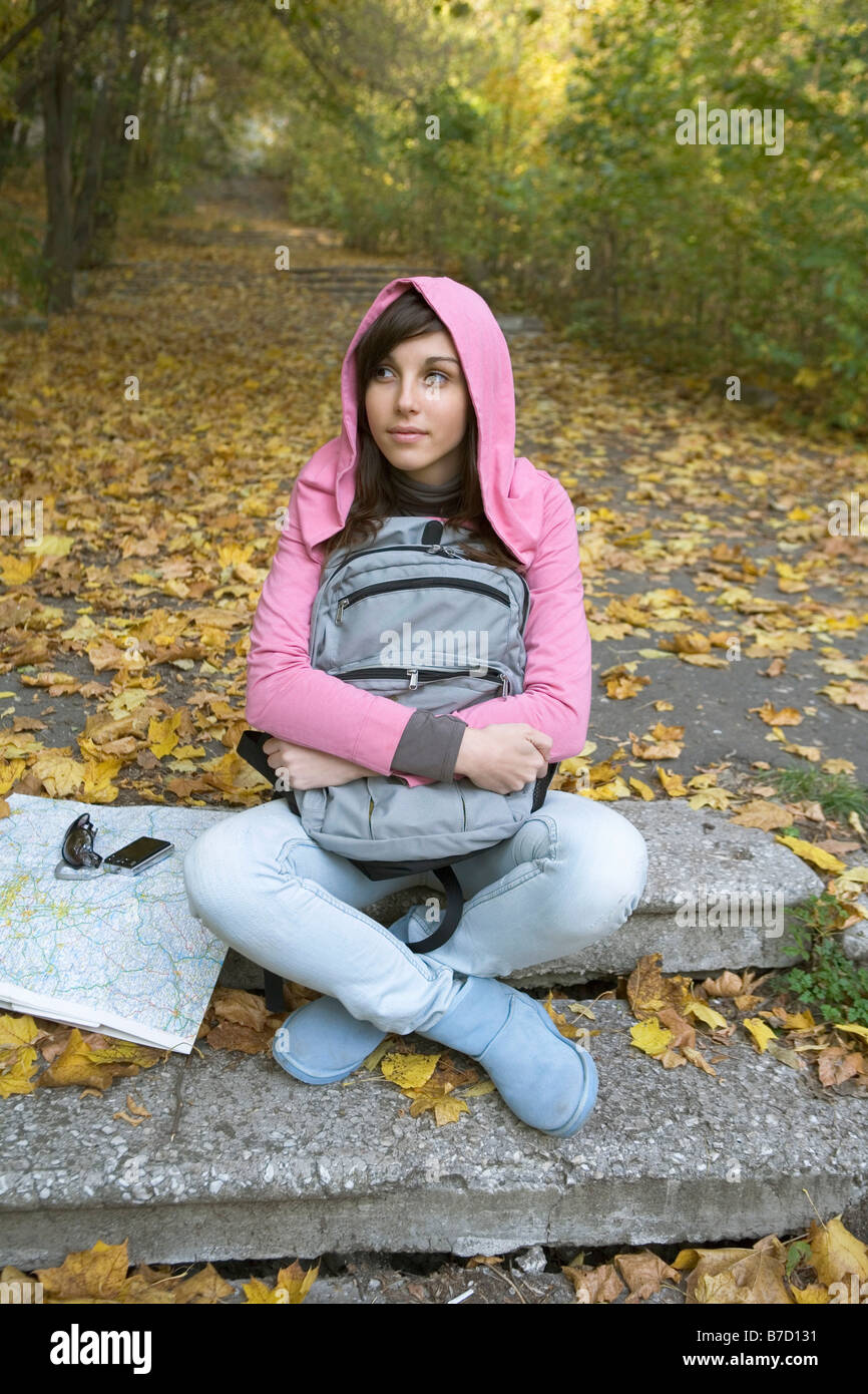 A teenage girl sitting outside in nature Stock Photo