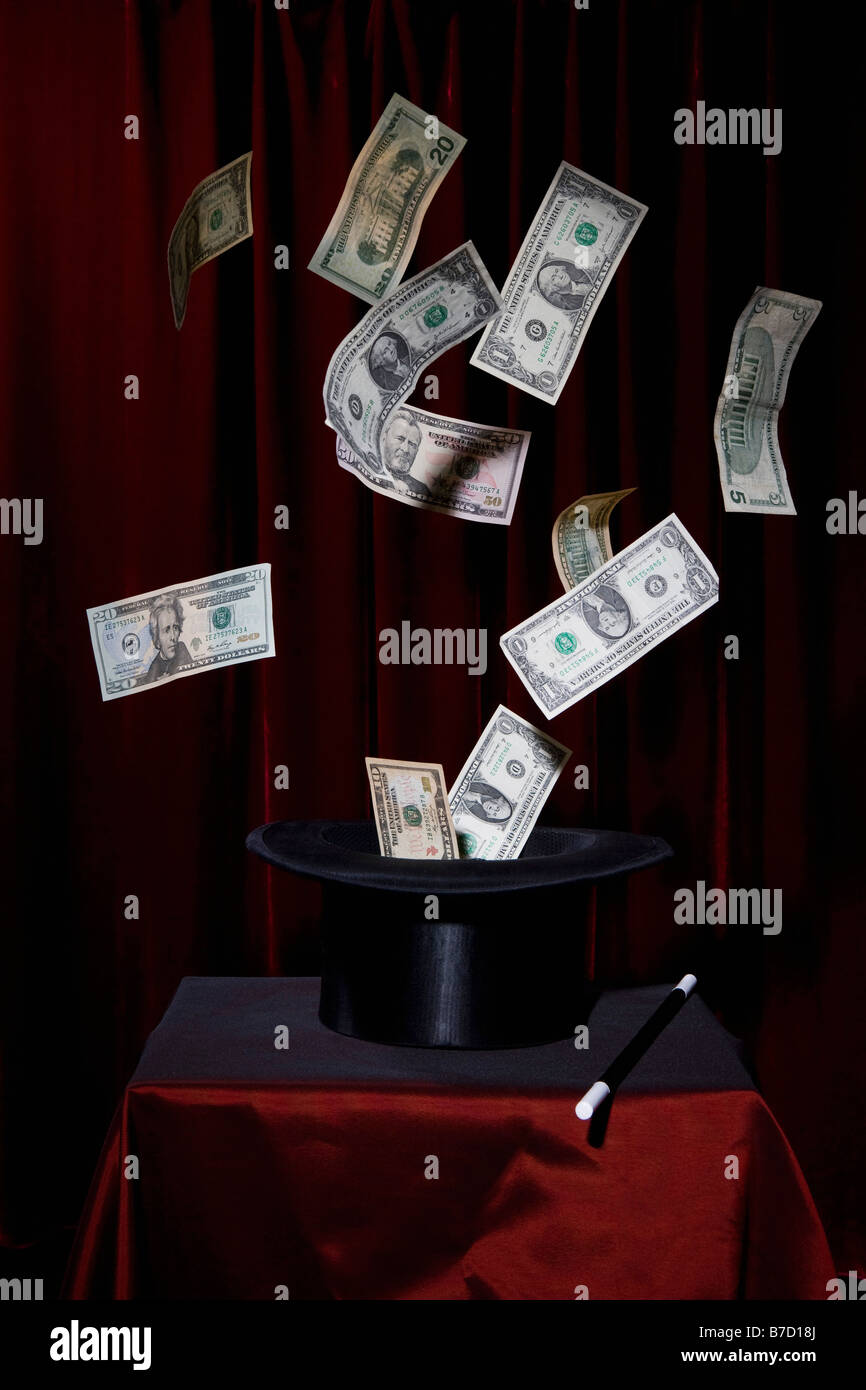 US currency bills coming out of a top hat at a magic show Stock Photo