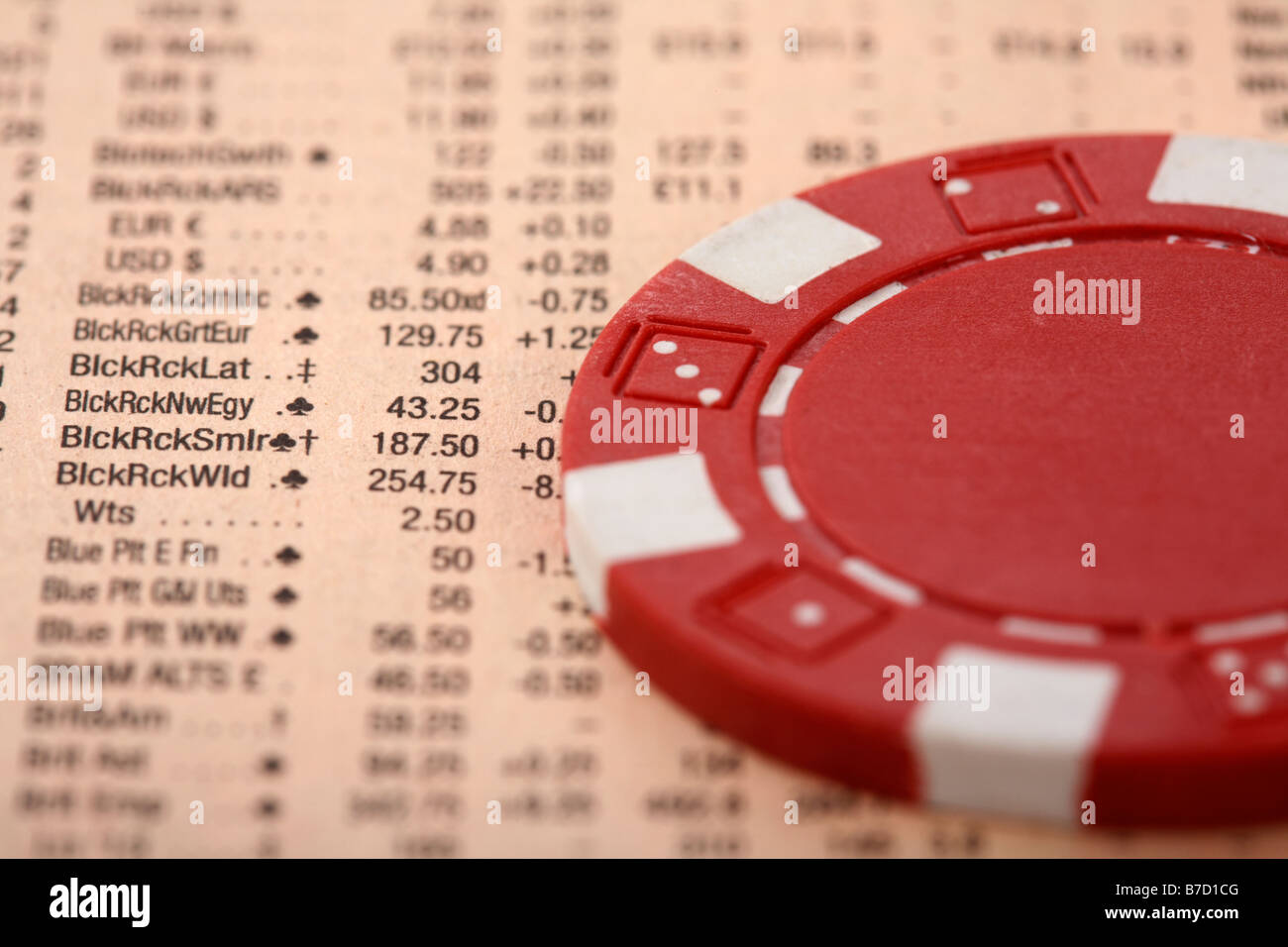 poker chip sitting on share information in a copy of the financial times concept on gambling in the stock market Stock Photo