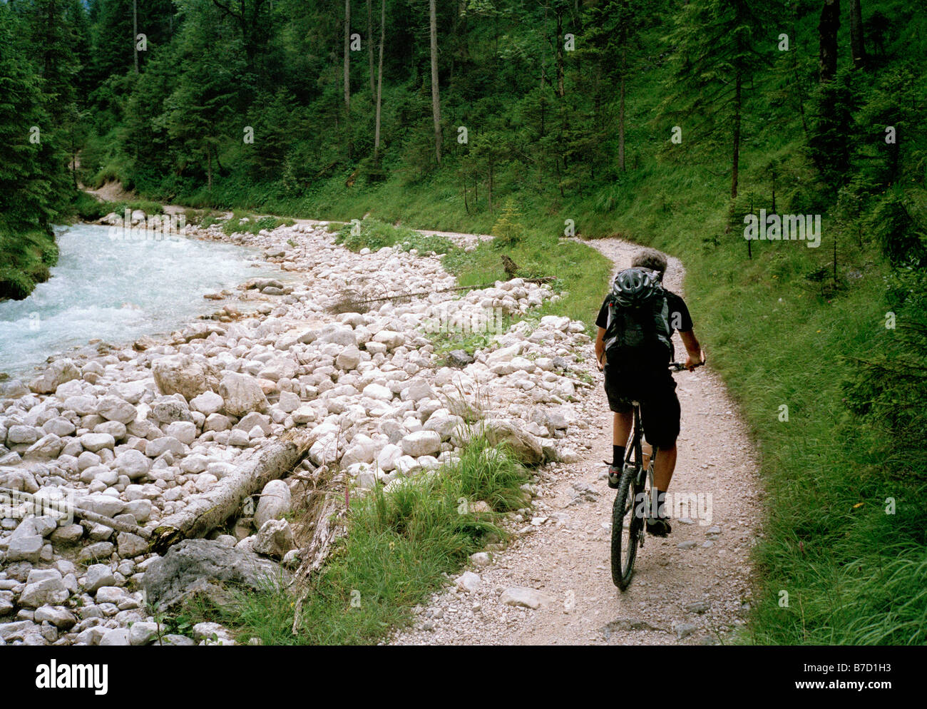 A man cycling alongside a river, Austria Stock Photo