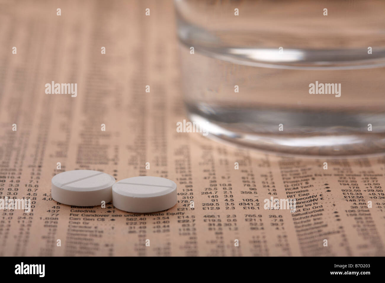 two paracetamol aspirin tablets sitting beside a glass of water on a