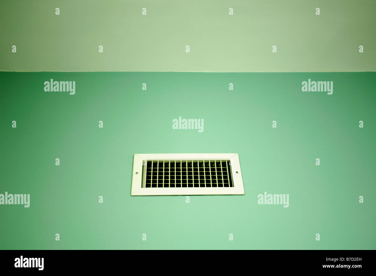 A small rectangular air vent on a green ceiling wall. Stock Photo