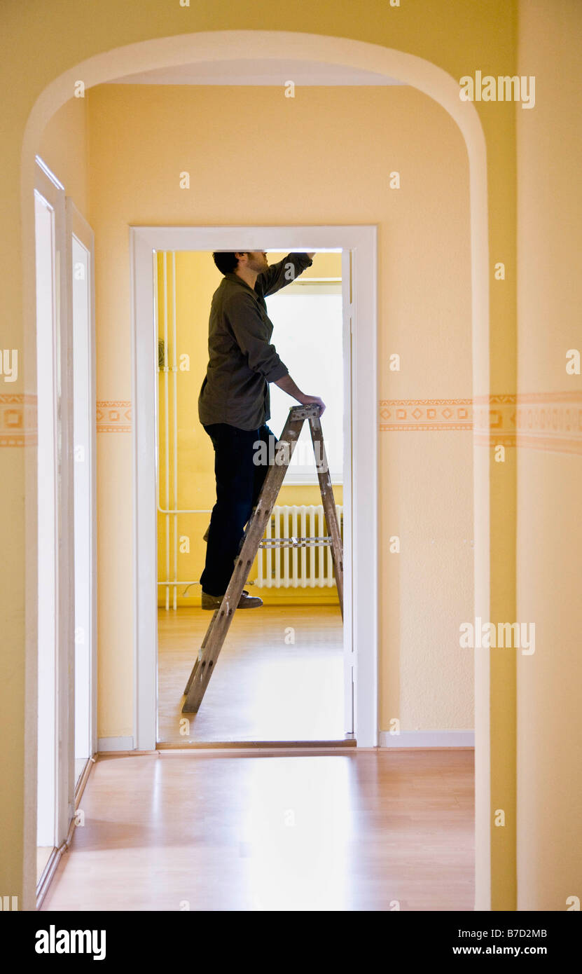 Man changing a lightbulb on a ladder Stock Photo Alamy