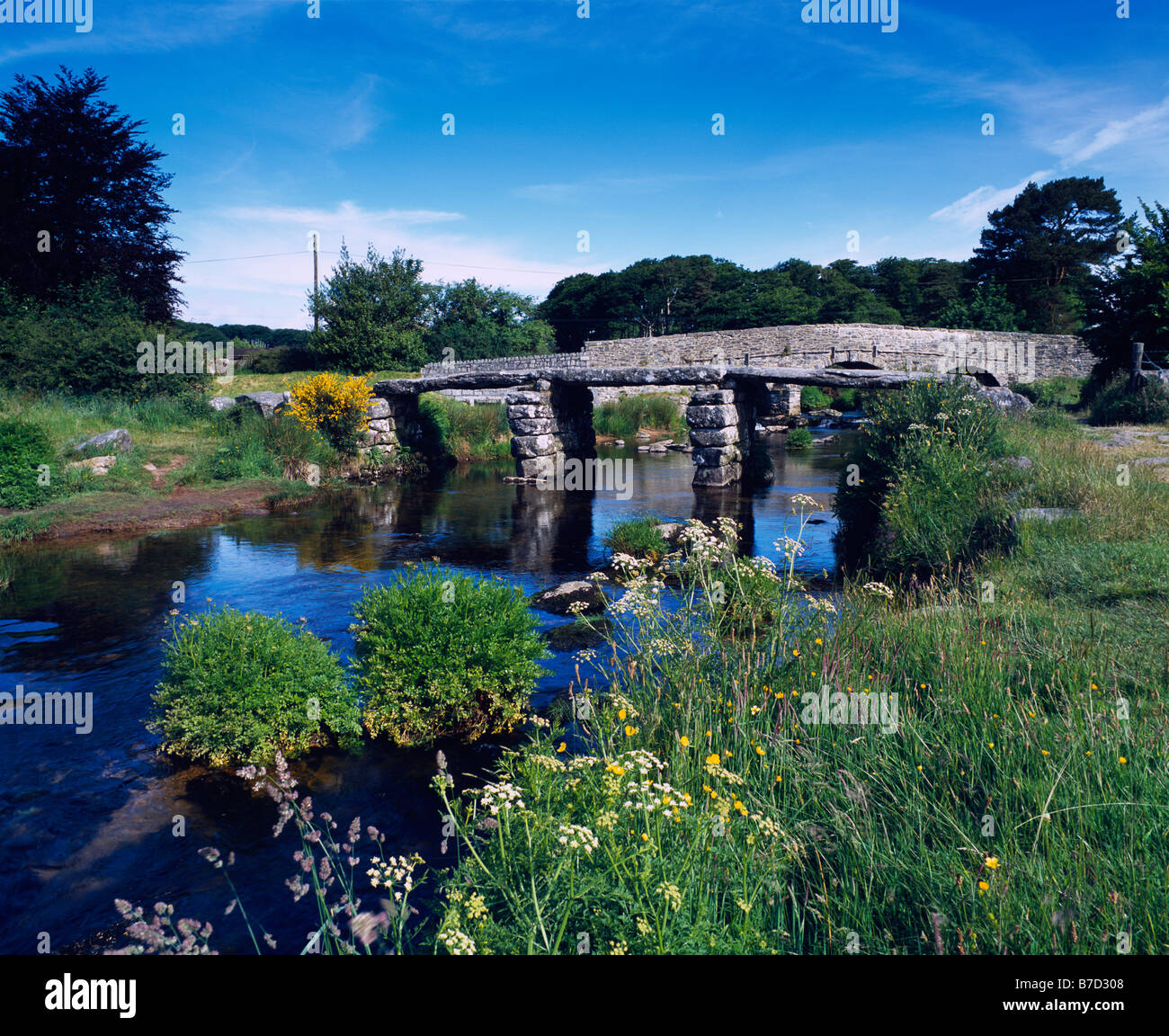 The old clapper bridge over the East Dart River at Postbridge in Dartmoor National Park, Devon, England. Stock Photo