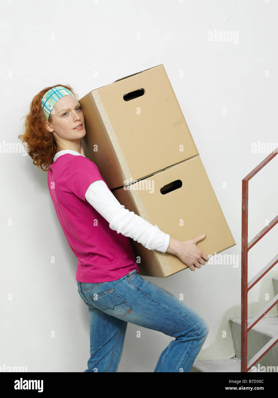 A woman carrying boxes up stairs Stock Photo Alamy