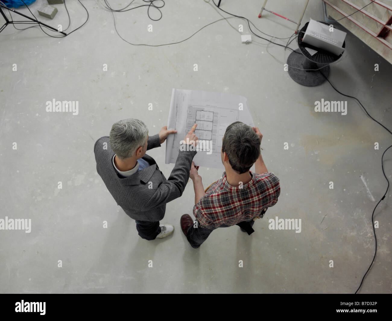 A construction worker going over blueprints with an architect Stock ...
