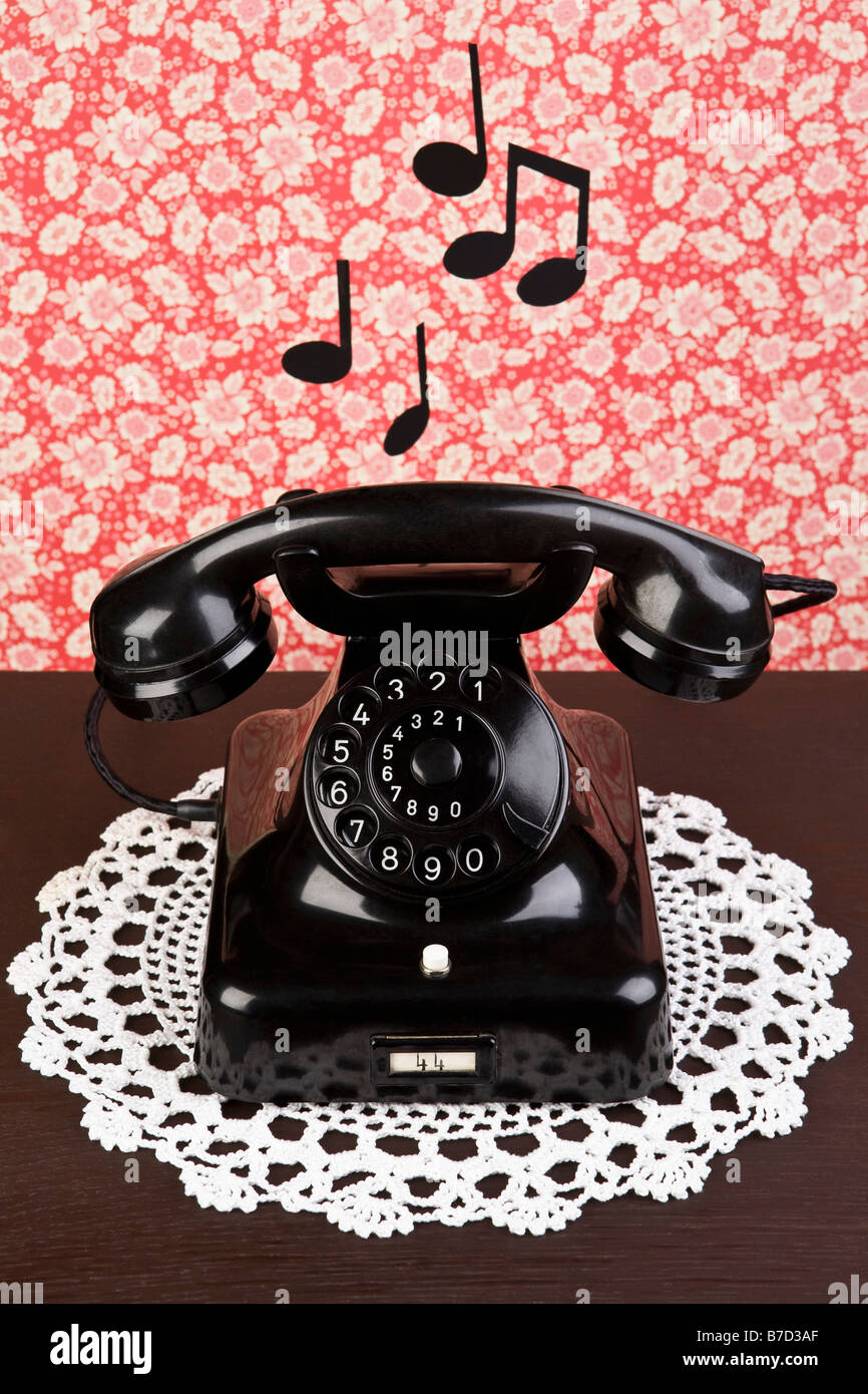 An old fashioned telephone on a dresser with musical notes Stock Photo