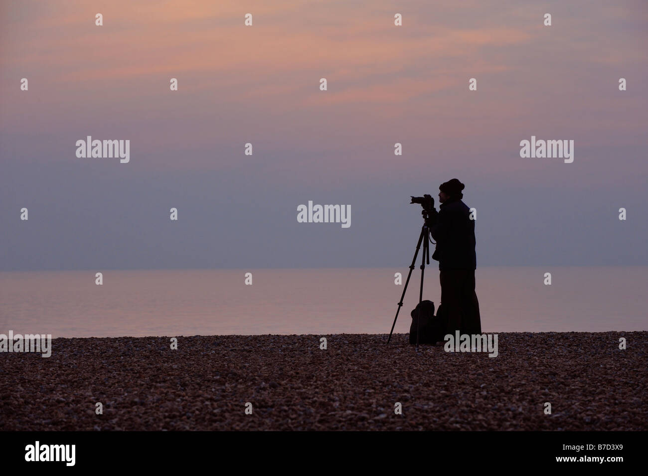 A keen amateur photographer with his camera on Brighton beach hoping to snap the starlings as they set to roost for the night. Stock Photo