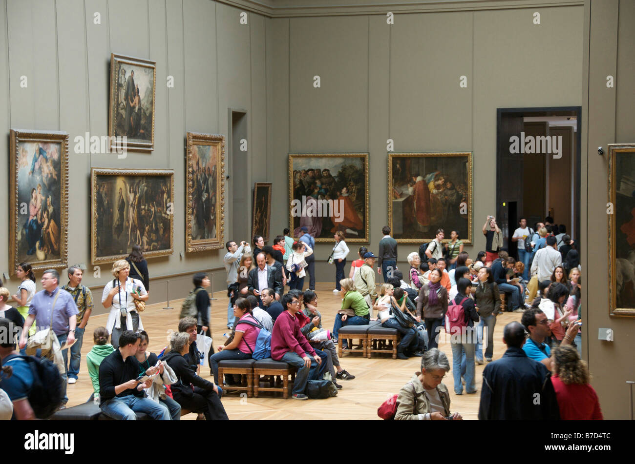 The Louvre, Paris - interior with people viewing the paintings Stock Photo