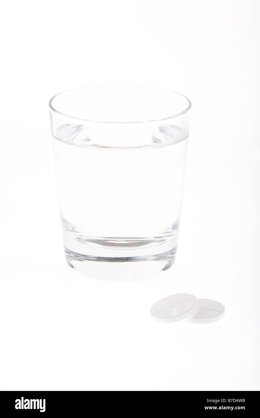 glass half full empty with water with two large soluble paracetamol tablets isolated on white background Stock Photo