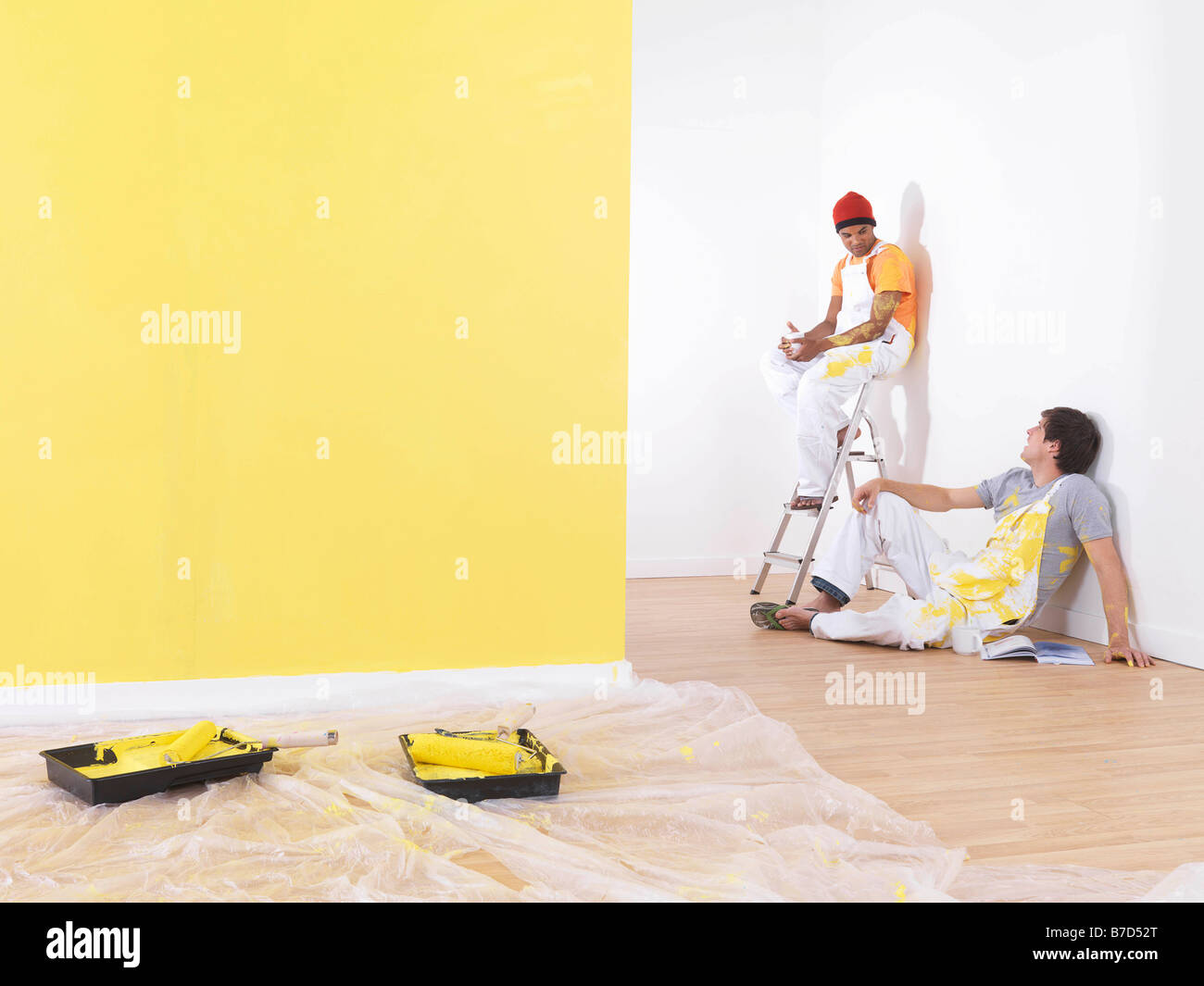 Men take a break from painting. Stock Photo