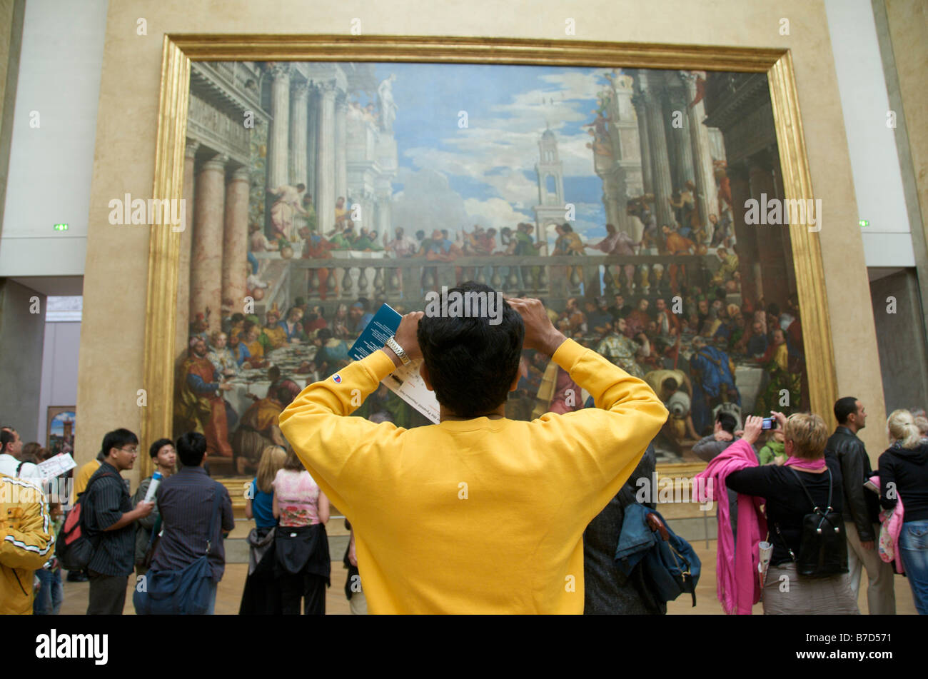 Louvre, Paris, interior - people inside taking photos of the paintings Stock Photo