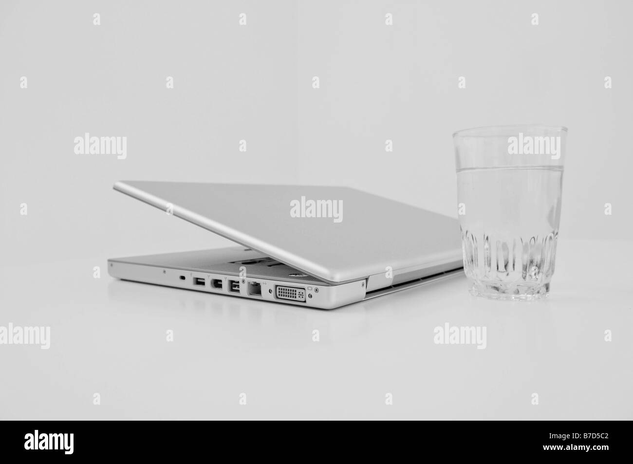 A laptop and a glass of water. Stock Photo