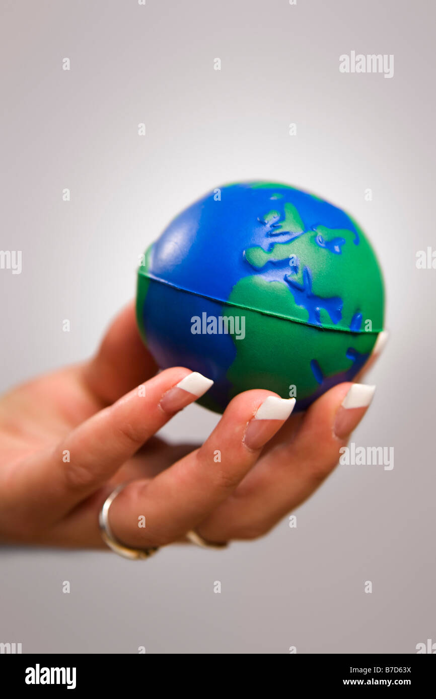 Woman's hand holding toy globe Stock Photo
