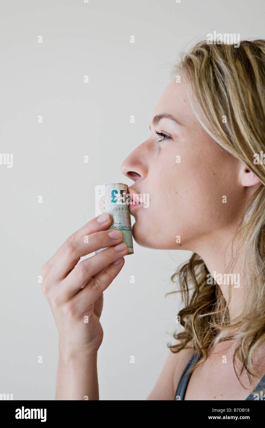 A female kissing a roll of money. Stock Photo