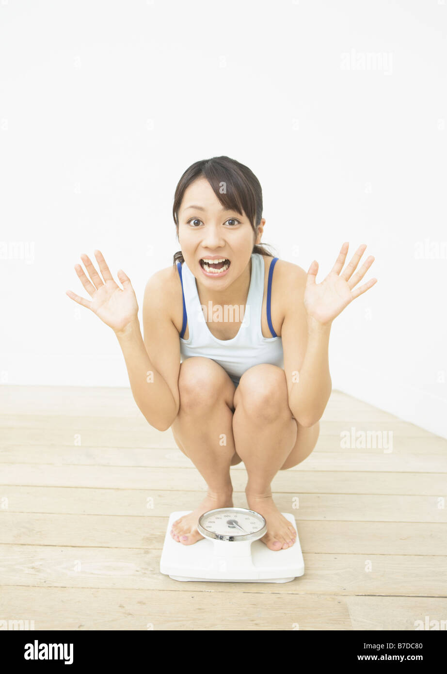Woman getting on the scale Stock Photo