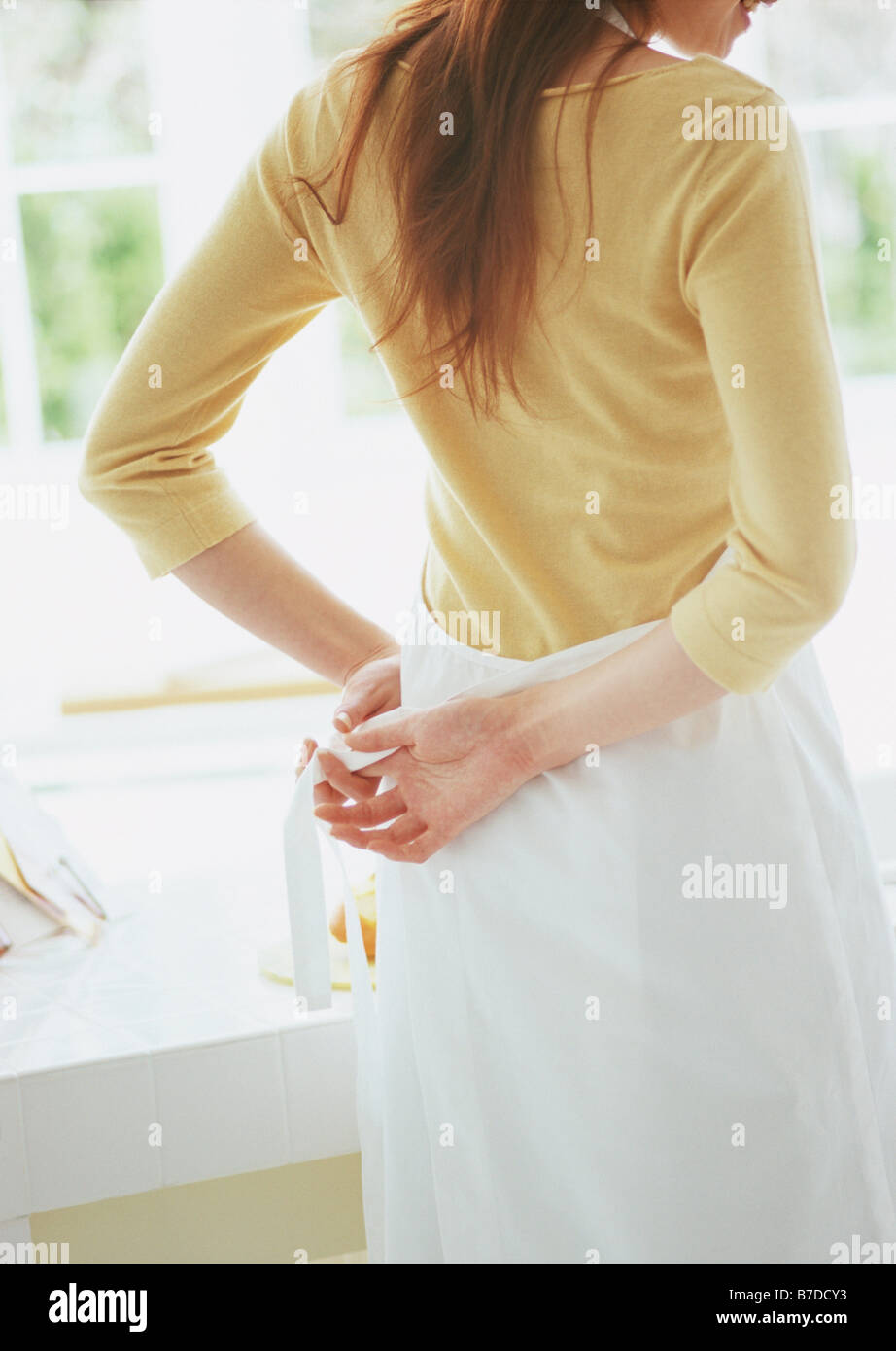 Woman tying apron strings Stock Photo Alamy