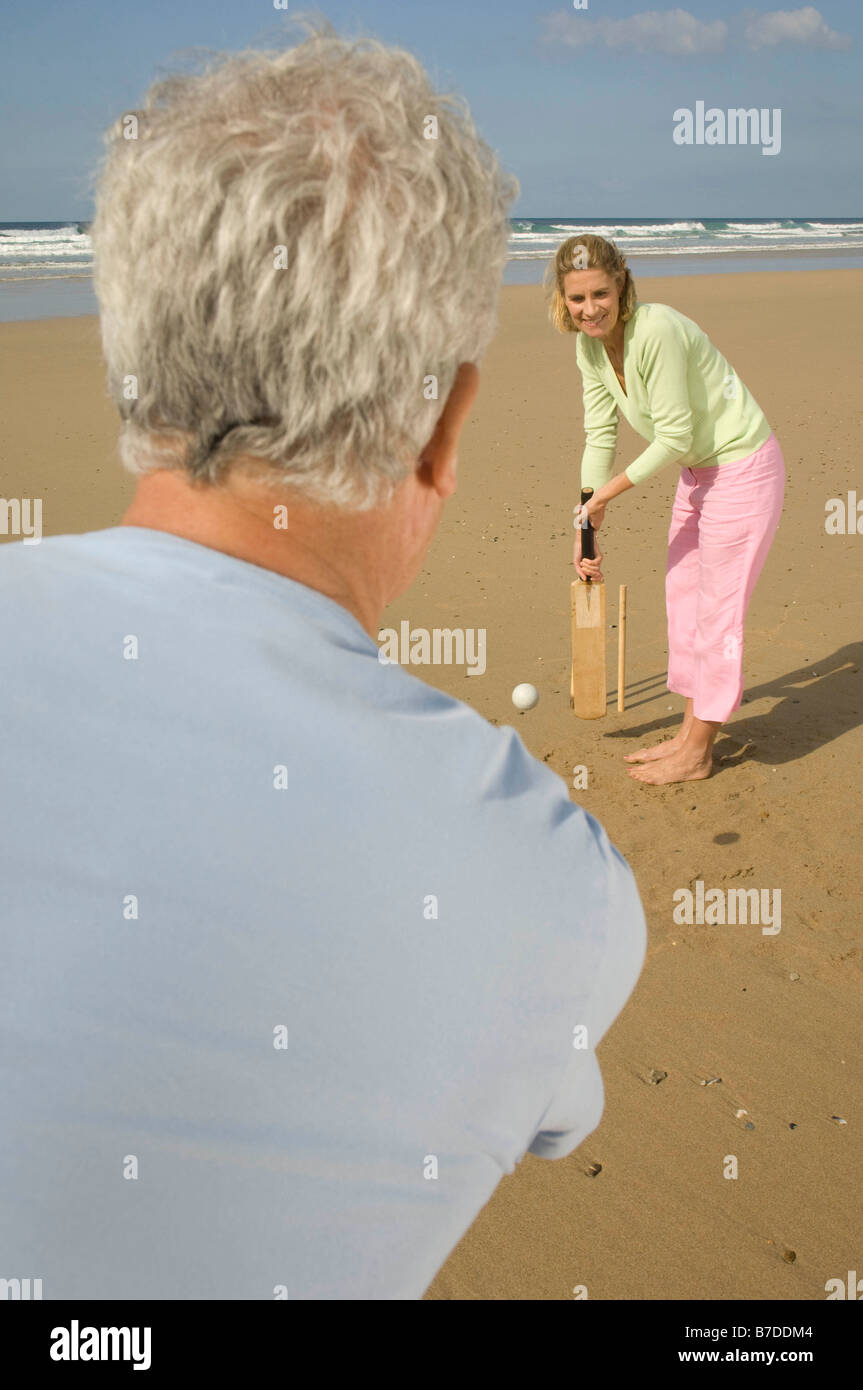 Couple playing cricket on a beach Stock Photo