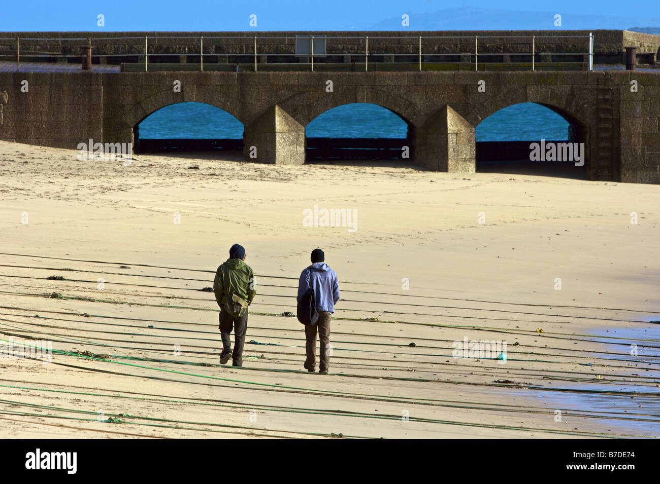 Two guys walking on the beach Stock Photo - Alamy