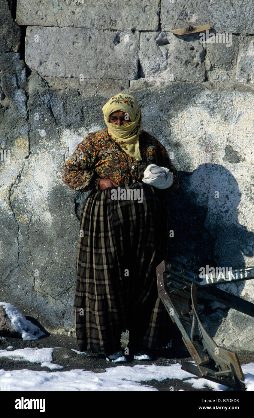 Woman dressed in head dress, long skirt and blouse holding wrapped cloth Wall CAPPADOCIA TURKEY Stock Photo