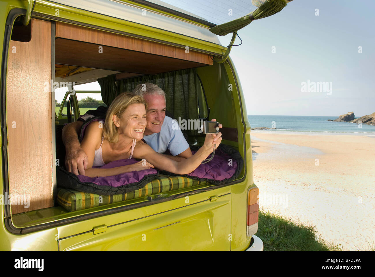 Mature couple lying in camper van Stock Photo - Alamy