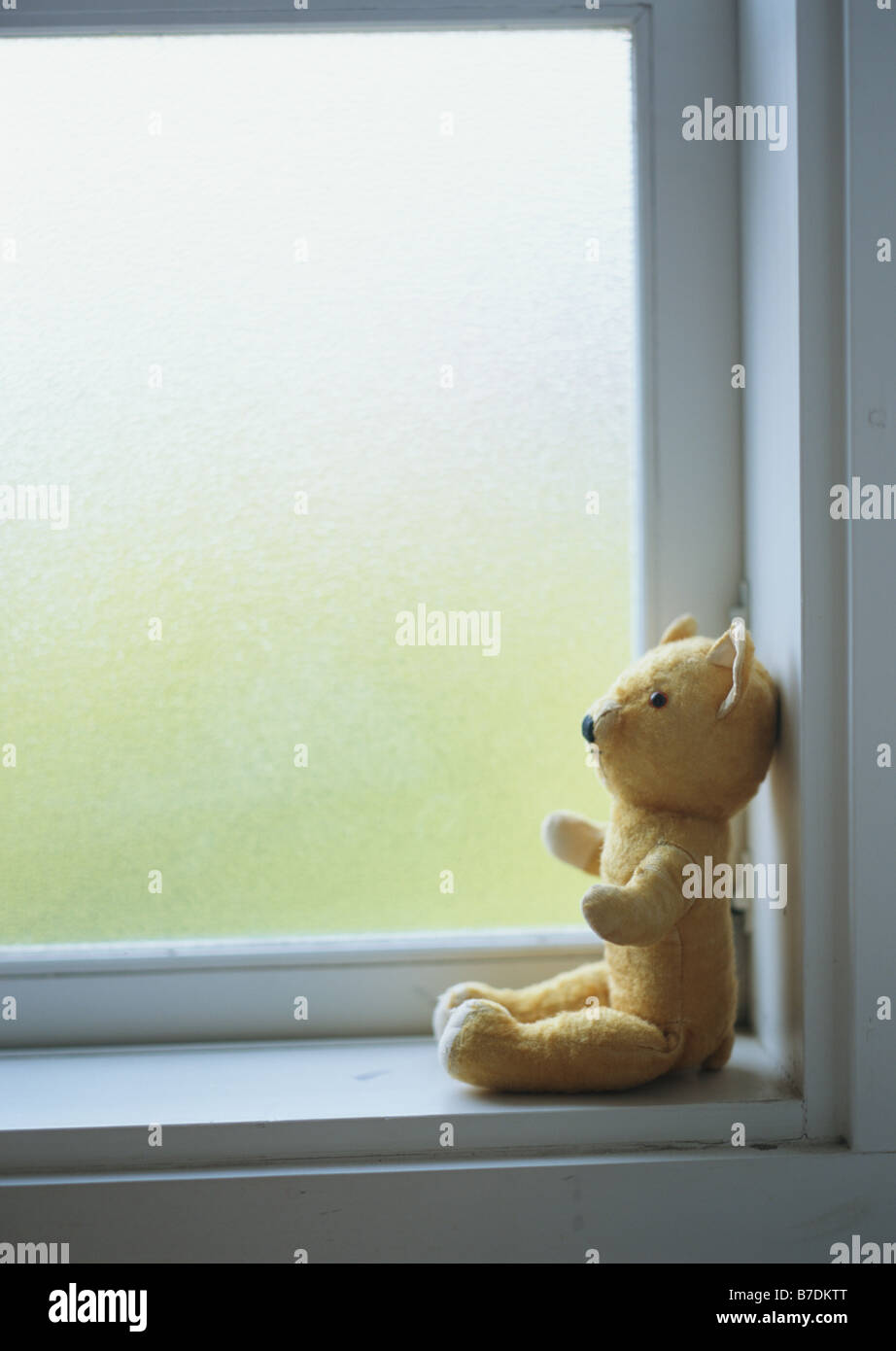 Teddy bear sitting on windowsill Stock Photo - Alamy