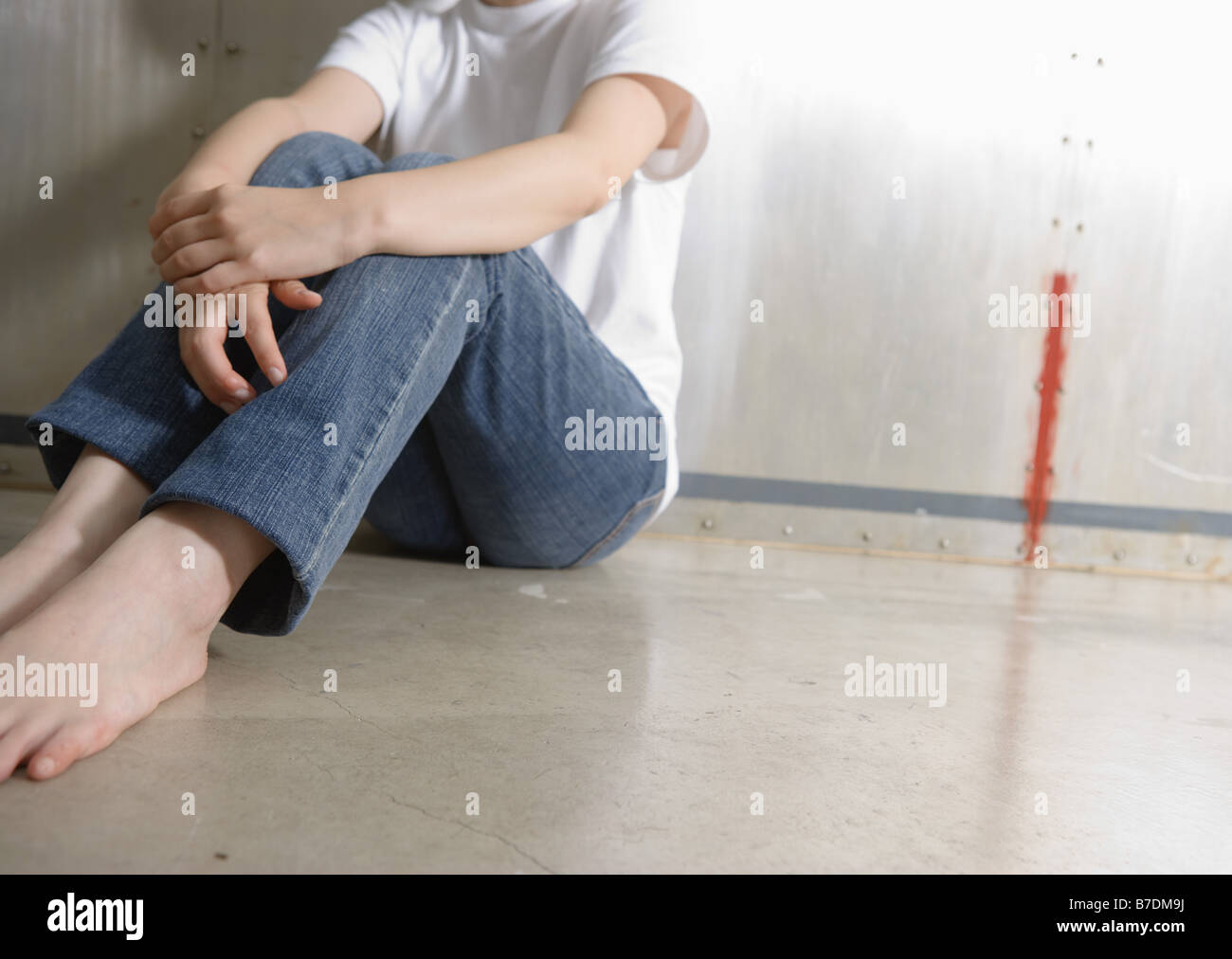 Woman sitting with arms around knees Stock Photo Alamy