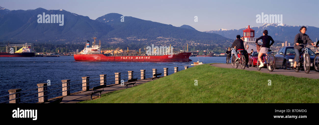 Freighter entering Port of Vancouver Harbour past Brockton Point Lighthouse in Stanley Park, Vancouver, British Columbia, Canada Stock Photo