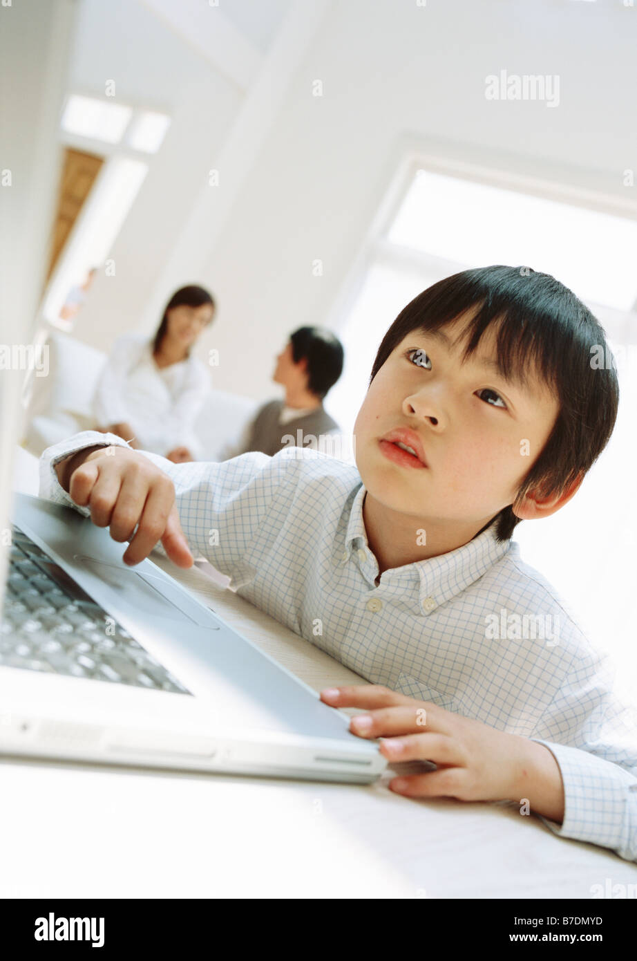 Boy using laptop at table Stock Photo - Alamy