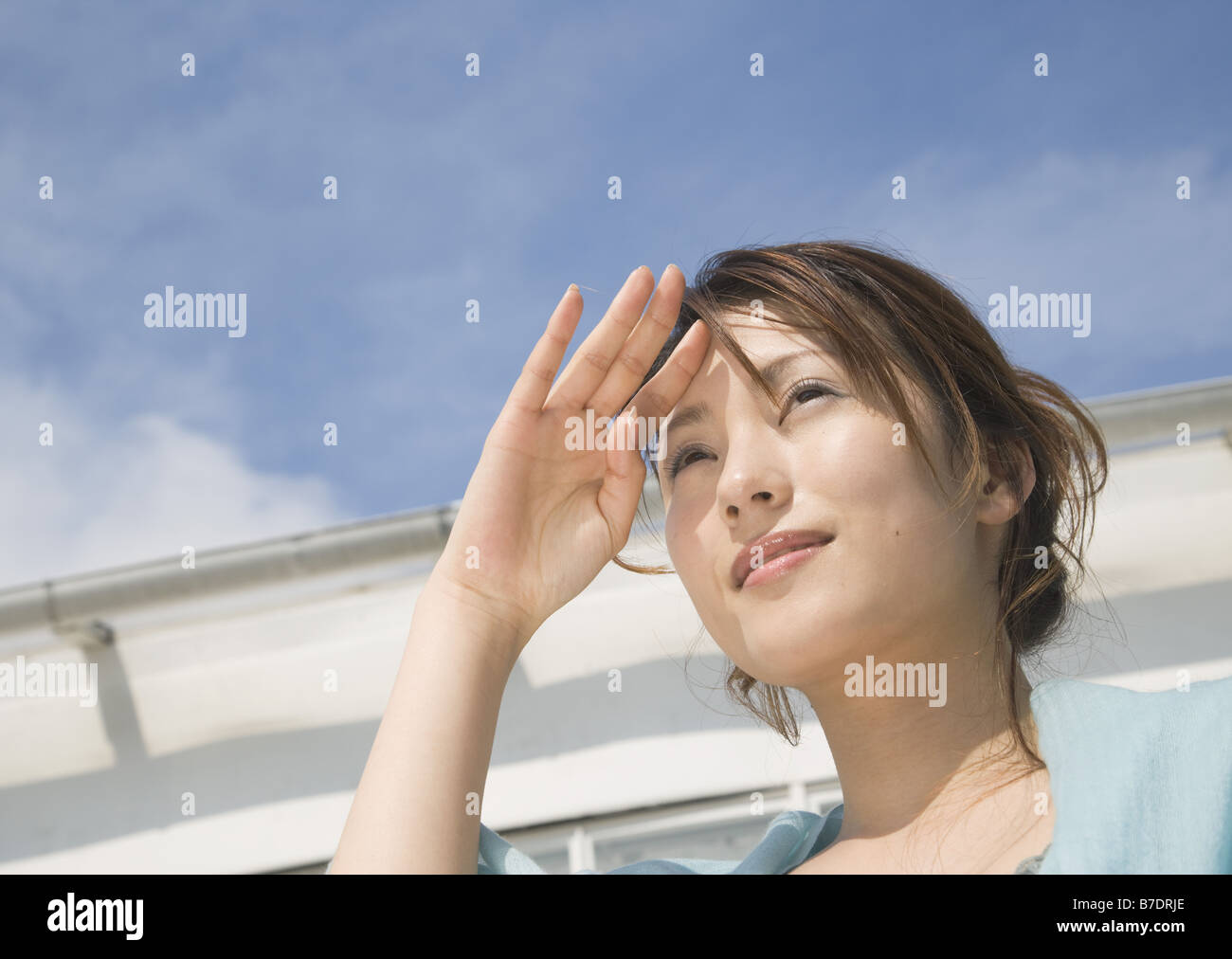 Woman shielding eyes from sun Stock Photo Alamy