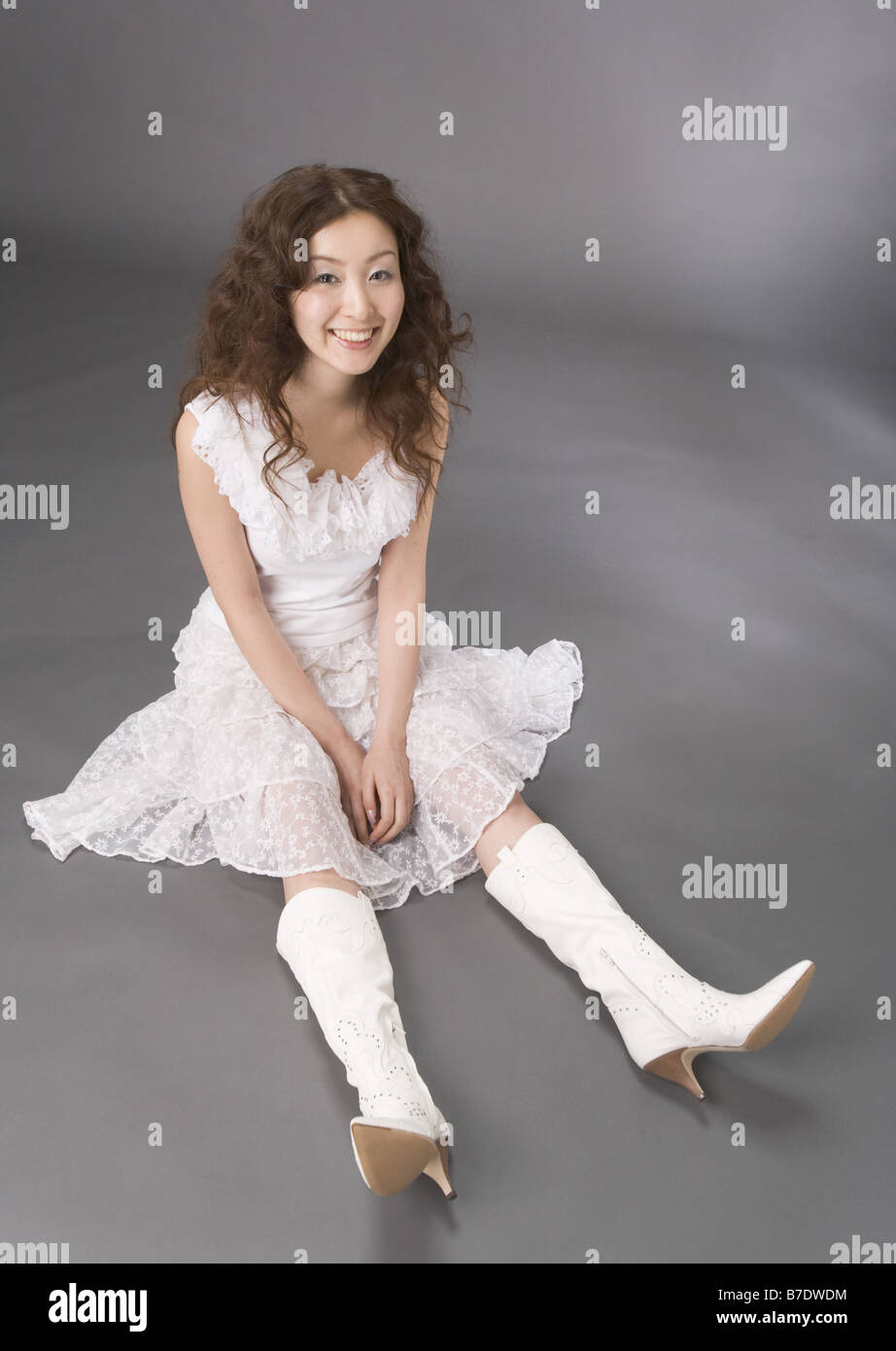 Woman in white dress sitting on floor Stock Photo - Alamy