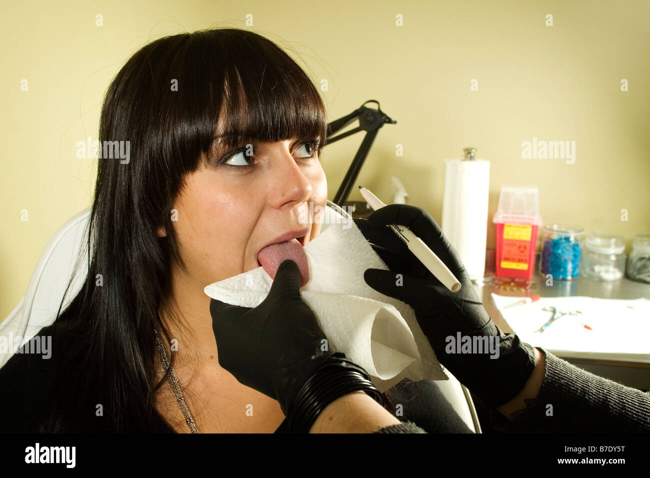 Girl getting ready to get her tongue pierced in tattoo shop - Stock Image Girl With Piercing Stock Photos & Girl With Piercing Stock Images ...