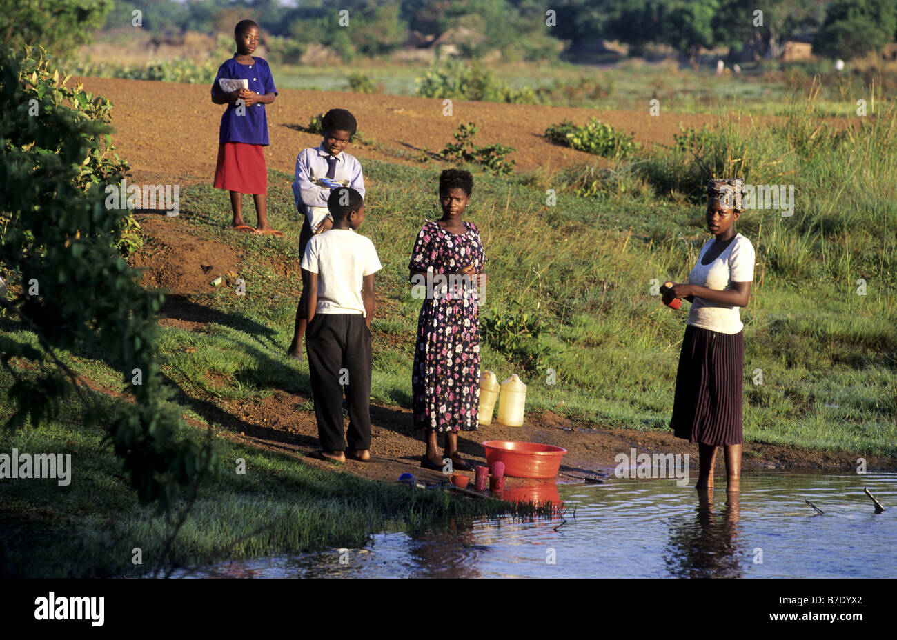 women and children at a waterhole, Zambia Stock Photo