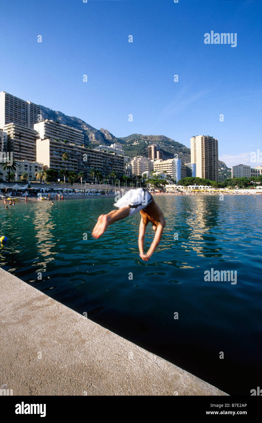 people diving from a pier in the beach of Larvotto in Monaco Stock Photo