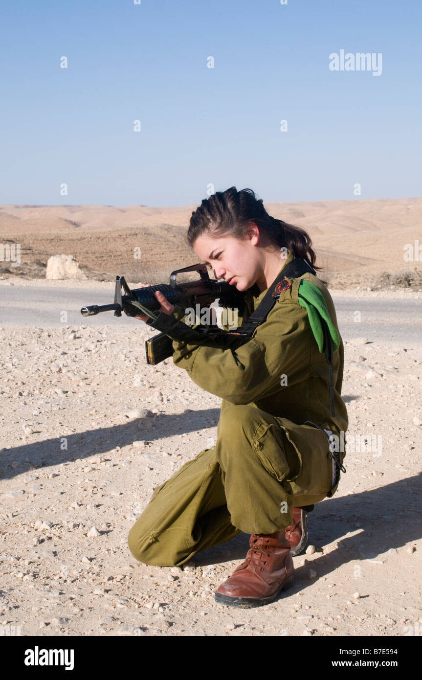 Israeli young female soldier in uniform aiming her M16 rifle Stock Photo