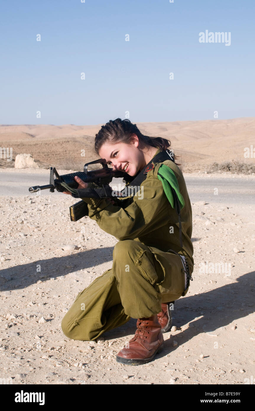 Israeli young female soldier in uniform aiming her M16 rifle Stock Photo