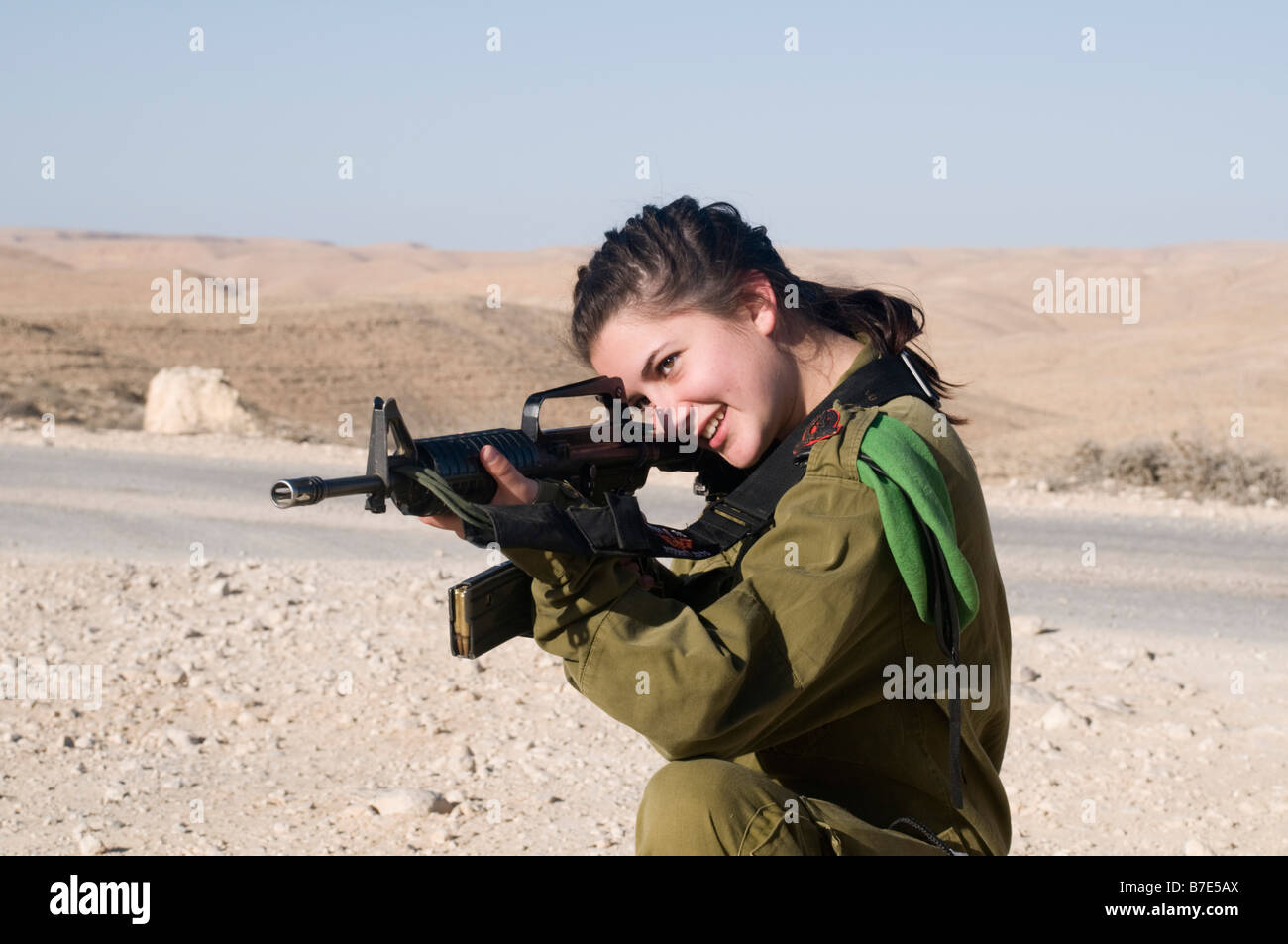 Israeli young female soldier in uniform aiming her M16 rifle Stock Photo