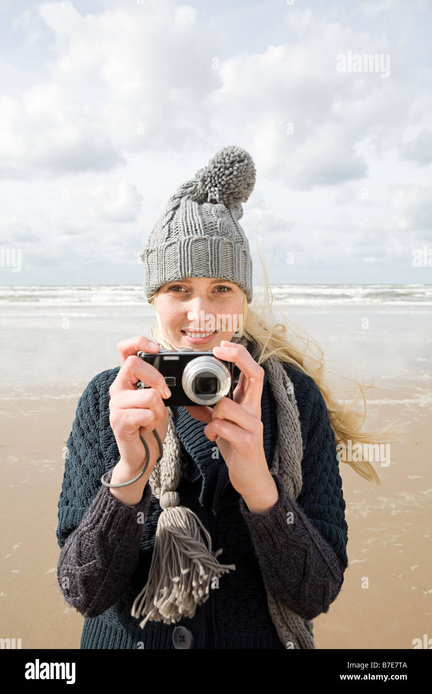 Woman by the sea with camera Stock Photo - Alamy